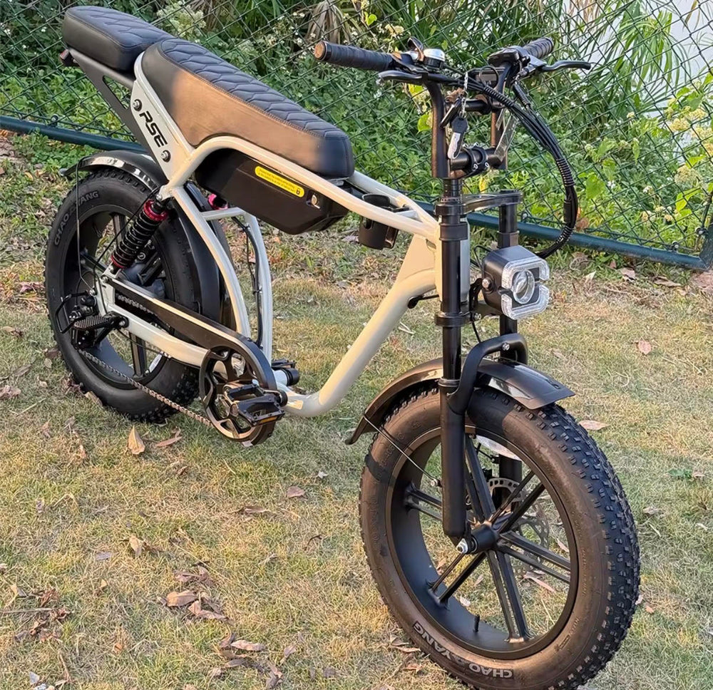 Thor Pulse RSE electric bike in Pebble colour parked on grass, featuring a step-through frame, fat tyres, front suspension, integrated headlight, rear suspension, and a long comfort seat
