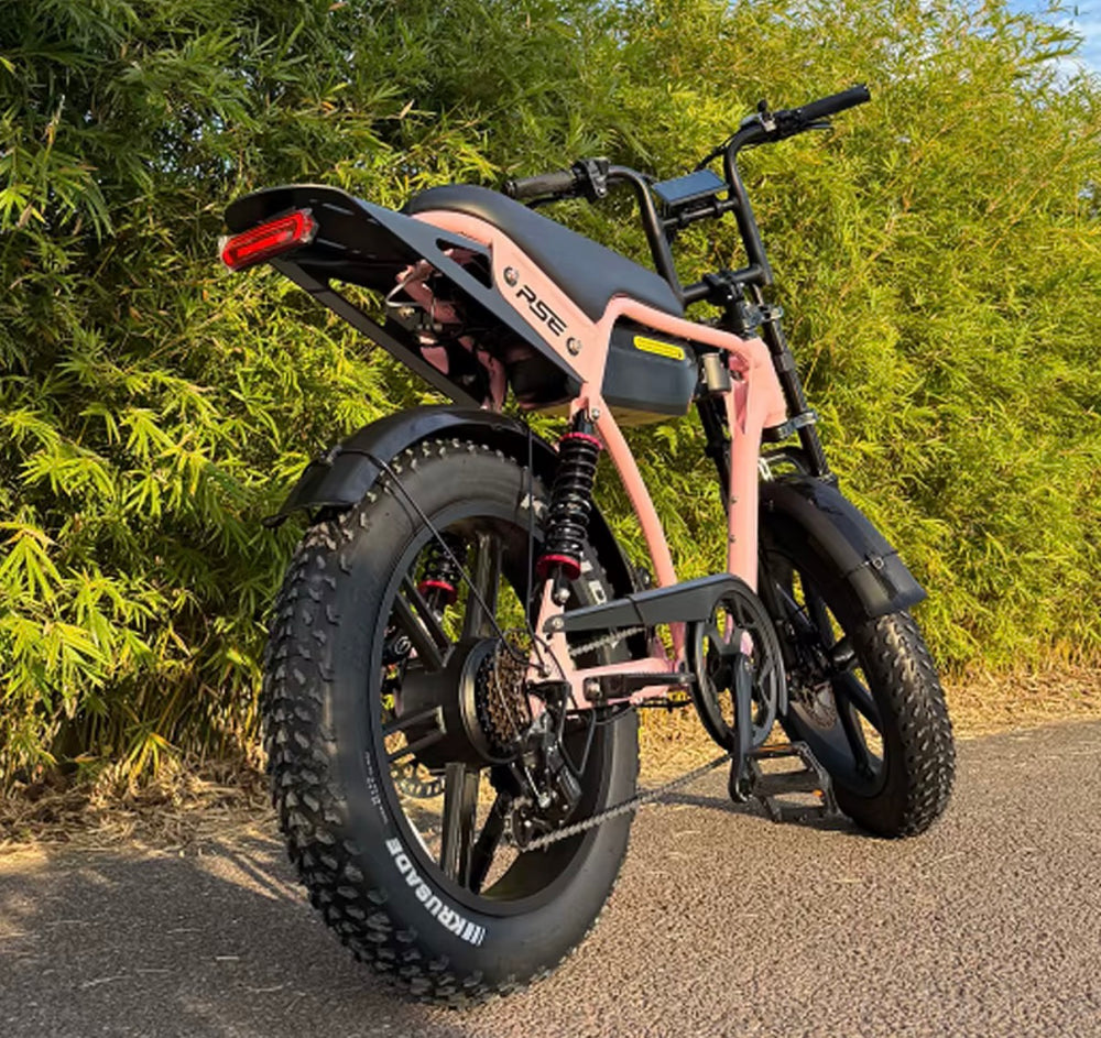 Pink Thor Pulse RSE fat tyre electric bike parked on a paved path with green trees in the background.